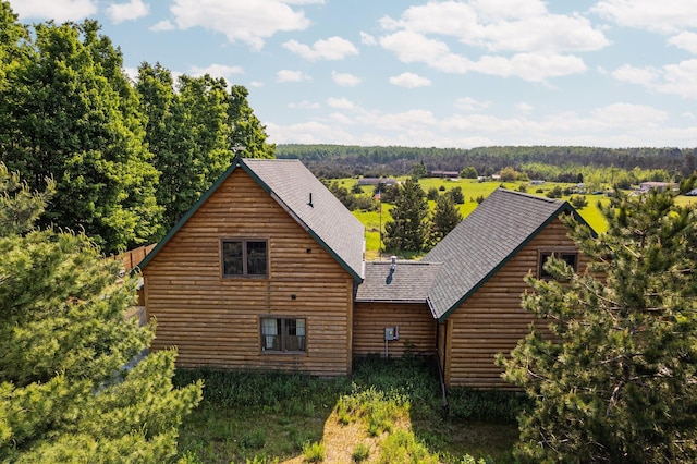 8406 S Shire Rd, Vanderbilt, MI 49795 - back of house with roof with shingles and a wooded view
