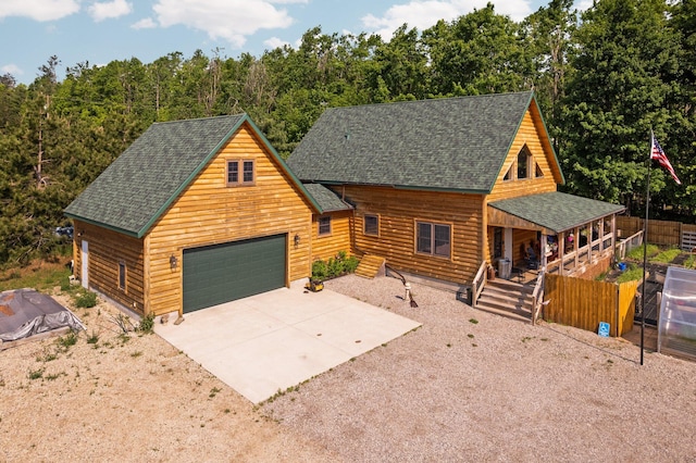 8406 S Shire Rd, Vanderbilt, MI 49795 - view of front facade featuring a shingled roof, covered porch, a garage, and concrete driveway