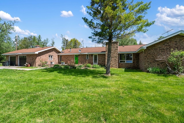 3869 Club Rd, Indian River, MI 49749 - back of property with a chimney, an attached garage, a lawn, and brick siding