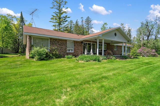 3869 Club Rd, Indian River, MI 49749 - view of front facade featuring a front yard, brick siding, and covered porch