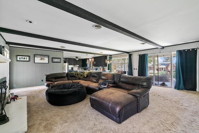 3869 Club Rd, Indian River, MI 49749 - living room featuring carpet, beam ceiling, a fireplace, and a chandelier
