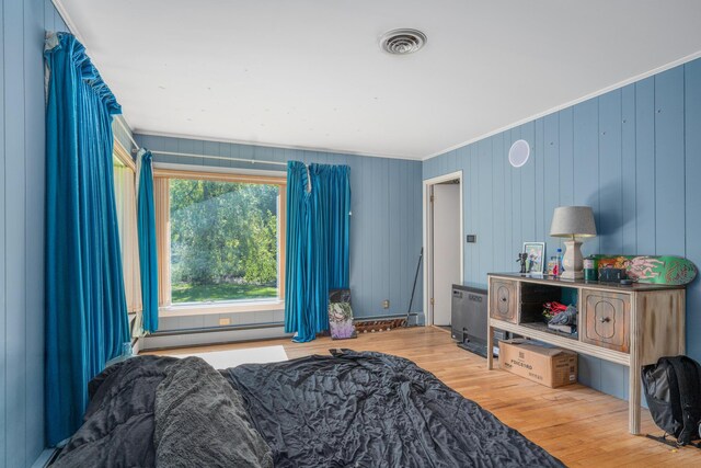 3869 Club Rd, Indian River, MI 49749 - bedroom with wood finished floors, a baseboard radiator, and ornamental molding
