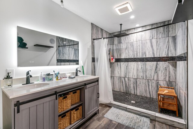3869 Club Rd, Indian River, MI 49749 - bathroom with a tile shower, double vanity, wood finished floors, and recessed lighting