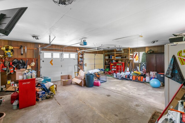 3869 Club Rd, Indian River, MI 49749 - garage featuring wood walls and a garage door opener
