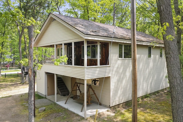 215 Pine Bluffs Rd, Roscommon, MI 48653 - rear view of property featuring a sunroom, a patio, and stairs