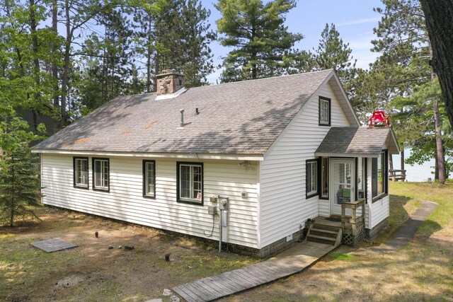 215 Pine Bluffs Rd, Roscommon, MI 48653 - rear view of property with a shingled roof, a chimney, and a sunroom
