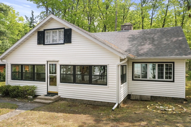 215 Pine Bluffs Rd, Roscommon, MI 48653 - view of front of house with a chimney, entry steps, and a shingled roof