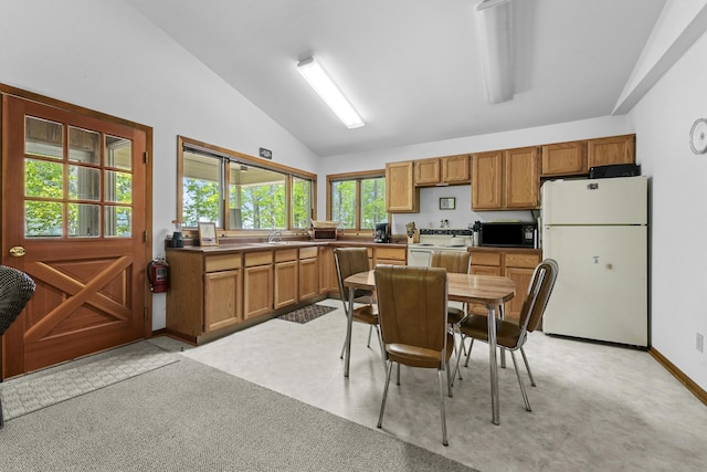 215 Pine Bluffs Rd, Roscommon, MI 48653 - kitchen featuring white appliances, lofted ceiling, brown cabinets, light colored carpet, and dark countertops