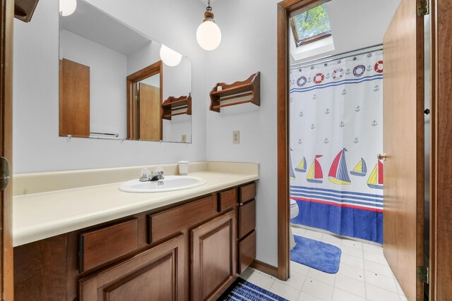 215 Pine Bluffs Rd, Roscommon, MI 48653 - full bath featuring toilet, vanity, tile patterned flooring, and a shower with curtain