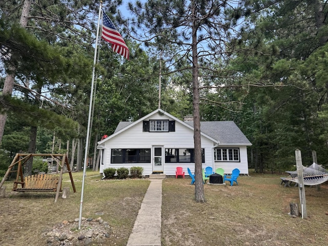 215 Pine Bluffs Rd, Roscommon, MI 48653 - back of house with a shingled roof, a yard, a sunroom, and view of wooded area