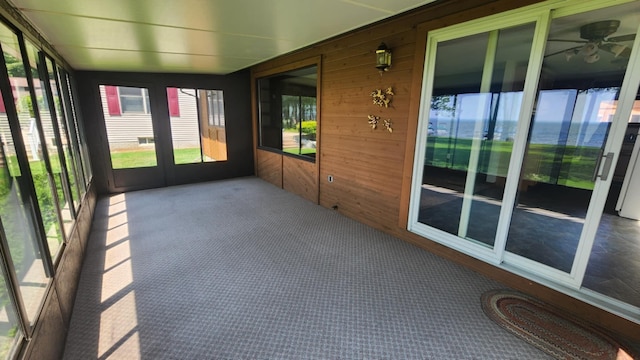 220 Mcdonald Dr, Houghton Lake, MI 48629 - unfurnished sunroom featuring carpet flooring, wood walls, and ceiling fan