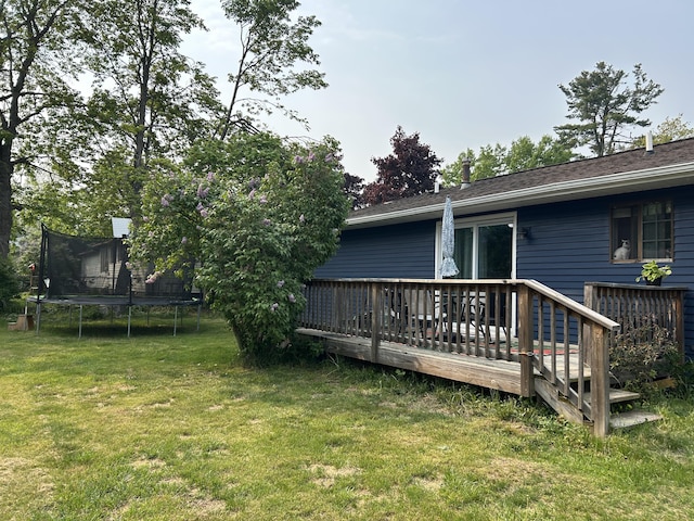 1200 Crestview Dr, Alpena, MI 49707 - view of green lawn featuring a trampoline and a wooden deck