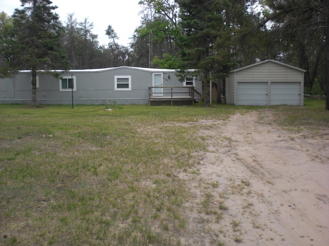 3123 Lovells Rd, Grayling, MI 49738 - view of front of house featuring a detached garage, an outdoor structure, a deck, dirt driveway, and a front yard