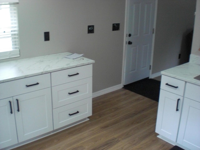 3123 Lovells Rd, Grayling, MI 49738 - kitchen with wood finished floors, white cabinets, and light stone counters