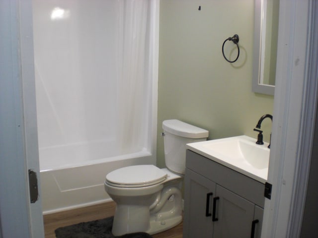 3123 Lovells Rd, Grayling, MI 49738 - bathroom with vanity, toilet, wood finished floors, and shower / bathtub combination with curtain