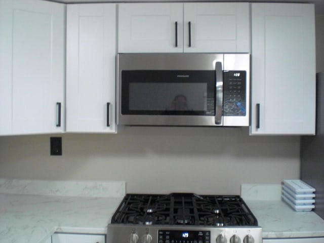 3123 Lovells Rd, Grayling, MI 49738 - kitchen view of stainless steel appliances, white cabinets, and light stone countertops