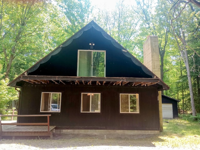 206 Redwine Dr, Houghton Lake, MI 48629 - view of side of home with a chimney