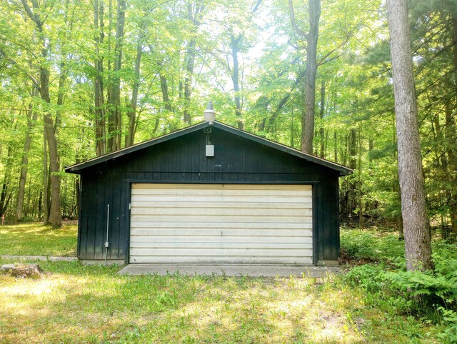 206 Redwine Dr, Houghton Lake, MI 48629 - detached garage with a view of trees