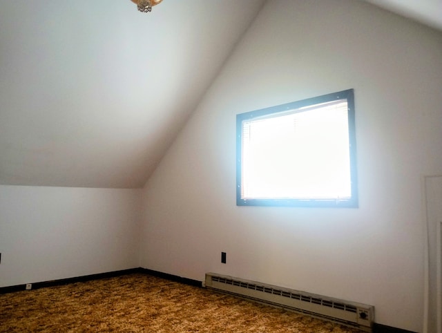 206 Redwine Dr, Houghton Lake, MI 48629 - additional living space featuring a baseboard radiator, lofted ceiling, and dark carpet