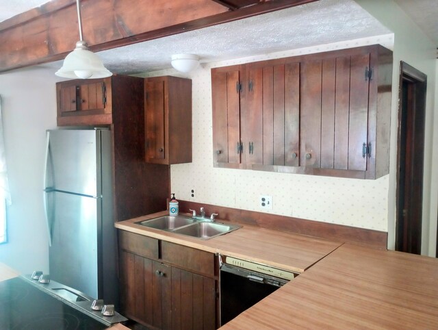 206 Redwine Dr, Houghton Lake, MI 48629 - kitchen featuring black dishwasher, freestanding refrigerator, a sink, light countertops, and decorative light fixtures