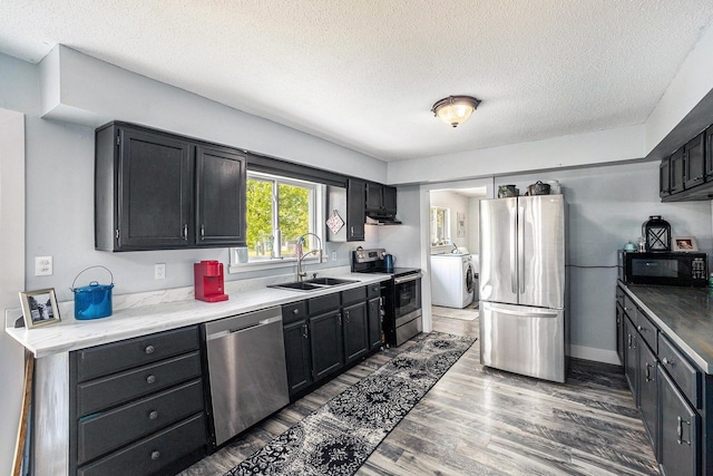 4844 Doerr Rd, Mancelona, MI 49659 - kitchen with appliances with stainless steel finishes, a sink, a textured ceiling, range hood, and wood finished floors