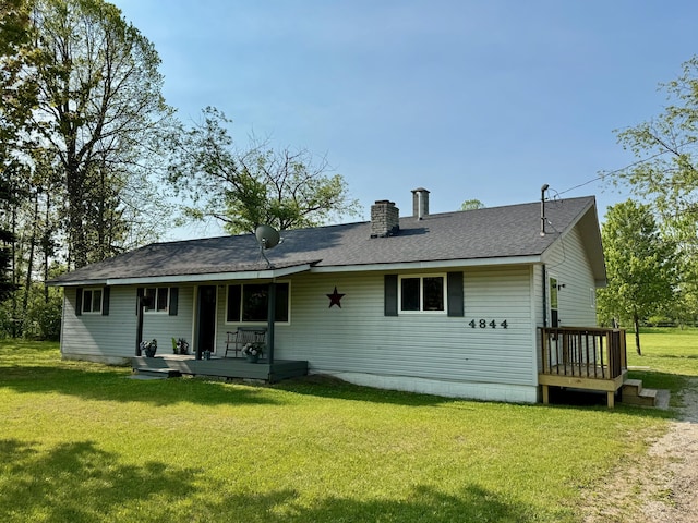 4844 Doerr Rd, Mancelona, MI 49659 - rear view of house featuring a chimney, a lawn, a porch, and roof with shingles