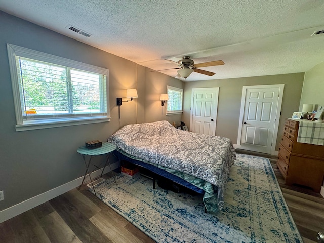 4844 Doerr Rd, Mancelona, MI 49659 - bedroom with a textured ceiling, dark wood-type flooring, ceiling fan, and baseboards
