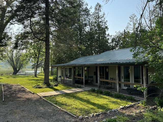 7386 Cheboygan St, Alanson, MI 49706 - back of house with a metal roof, a lawn, and a patio area