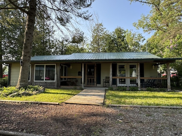 7386 Cheboygan St, Alanson, MI 49706 - view of front of property featuring covered porch, a front lawn, and a metal roof