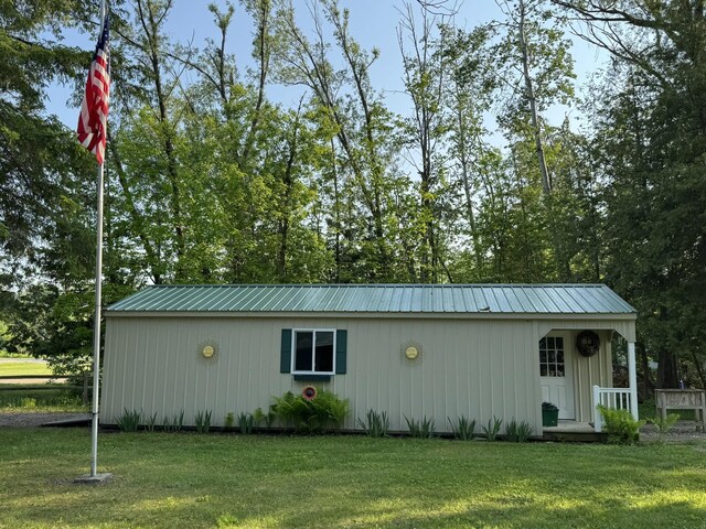 7386 Cheboygan St, Alanson, MI 49706 - view of side of home with a yard and a metal roof