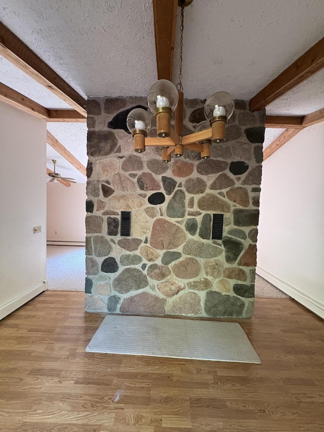 20730 E Riverside Dr, Hillman, MI 49746 - detailed view of beamed ceiling, a textured ceiling, baseboards, wood finished floors, and ceiling fan