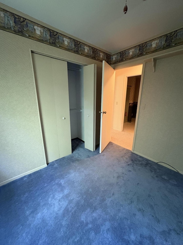 20730 E Riverside Dr, Hillman, MI 49746 - unfurnished bedroom with carpet floors, wallpapered walls, and a closet