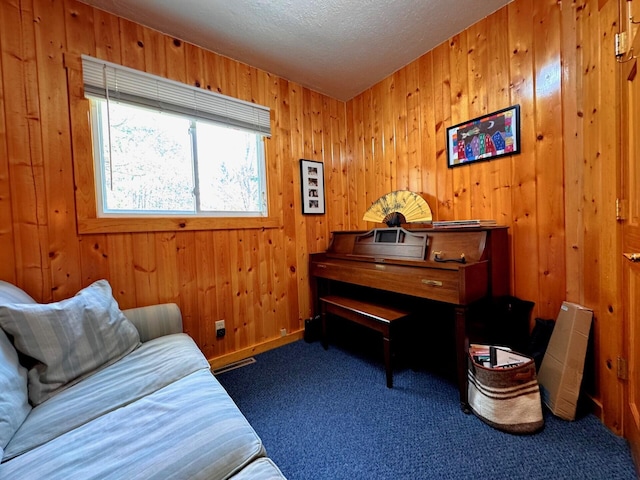 6309 Hiawatha Dr, Frederic, MI 49733 - sitting room with dark colored carpet, wood walls, and a textured ceiling