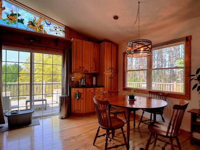 6309 Hiawatha Dr, Frederic, MI 49733 - dining area featuring lofted ceiling, light wood-type flooring, and a chandelier