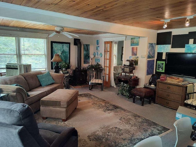 17740 Grand Lake Blvd, Presque Isle, MI 49777 - carpeted living room featuring a wood stove, ornamental molding, wood ceiling, cooling unit, and a ceiling fan