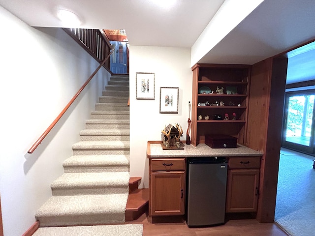 5392 Silver Beach Rd, Onaway, MI 49765 - indoor dry bar featuring refrigerator, stairway, and light wood-style floors