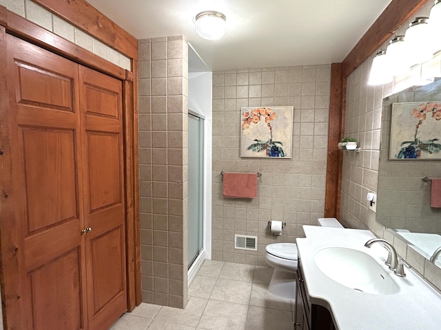 5392 Silver Beach Rd, Onaway, MI 49765 - bathroom featuring tile walls, tile patterned flooring, a stall shower, vanity, and toilet