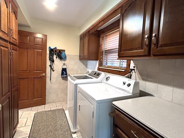 5392 Silver Beach Rd, Onaway, MI 49765 - laundry room with cabinet space, separate washer and dryer, and tile walls