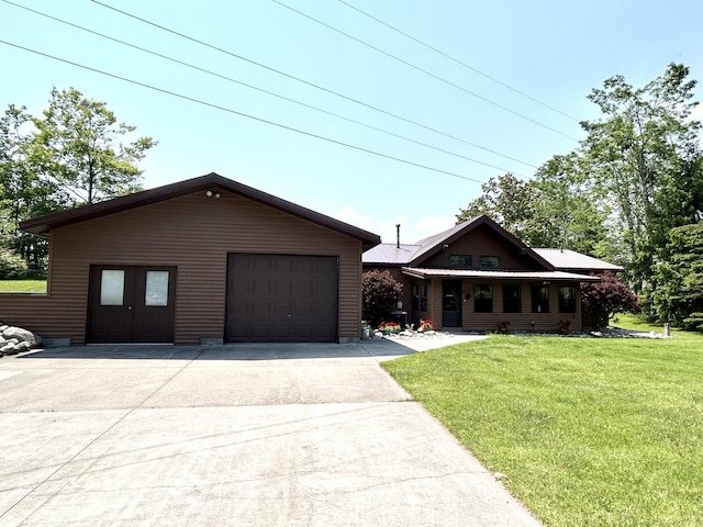 5392 Silver Beach Rd, Onaway, MI 49765 - view of front facade with a front yard, concrete driveway, and a garage