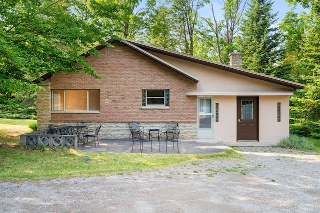 9150 W M-68, Indian River, MI 49749 - back of house featuring a patio area, a chimney, and brick siding