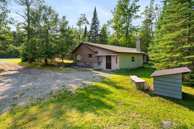 9150 W M-68, Indian River, MI 49749 - view of front of home featuring a chimney, a front lawn, and a patio
