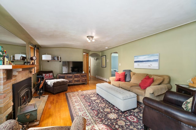 9150 W M-68, Indian River, MI 49749 - living room with arched walkways, a baseboard radiator, and wood finished floors