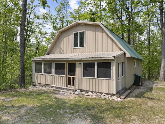 3221 Krause Rd, Petoskey, MI 49770 - view of front of property featuring a sunroom, metal roof, and a front lawn