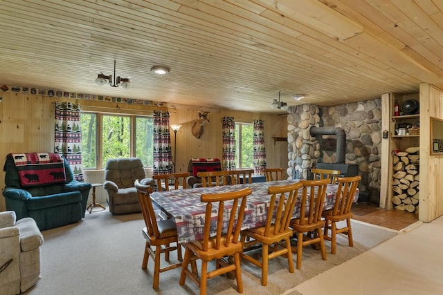 3221 Krause Rd, Petoskey, MI 49770 - dining space with a wood stove, wooden ceiling, and wood walls