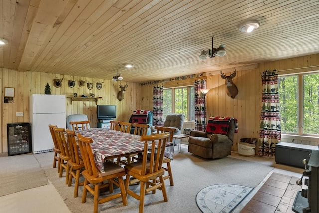 3221 Krause Rd, Petoskey, MI 49770 - dining area with wine cooler, wooden walls, wooden ceiling, and light colored carpet