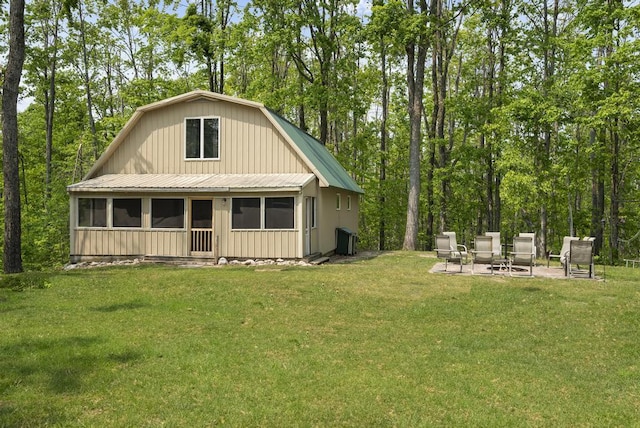 3221 Krause Rd, Petoskey, MI 49770 - rear view of property with a gambrel roof, a sunroom, and a lawn
