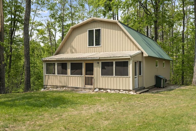 3221 Krause Rd, Petoskey, MI 49770 - view of front facade featuring a sunroom, central AC, and a front lawn