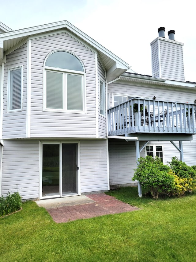 166 Long Rapids Rd, Alpena, MI 49707 - rear view of property featuring a lawn, a chimney, a patio area, and a wooden deck