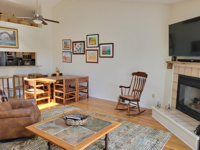 166 Long Rapids Rd, Alpena, MI 49707 - living area with wood finished floors, a fireplace, ceiling fan, baseboards, and lofted ceiling