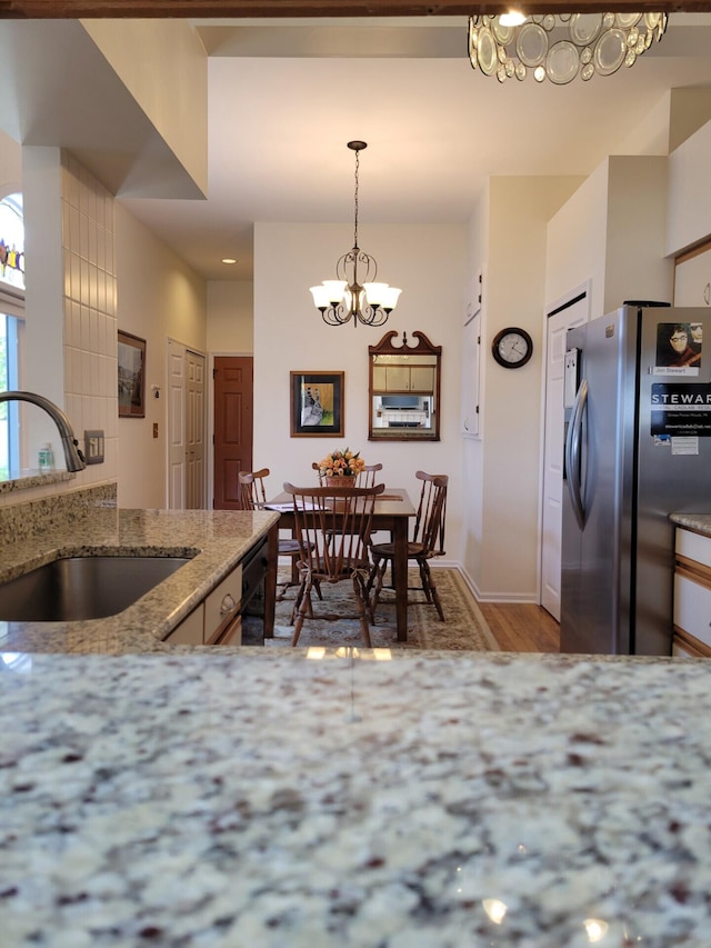 166 Long Rapids Rd, Alpena, MI 49707 - kitchen with stainless steel refrigerator with ice dispenser, a sink, a chandelier, light wood-style flooring, and light stone countertops
